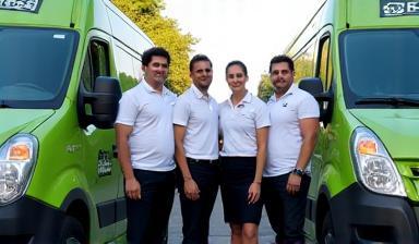 SwiftTrack team standing by branded delivery vans